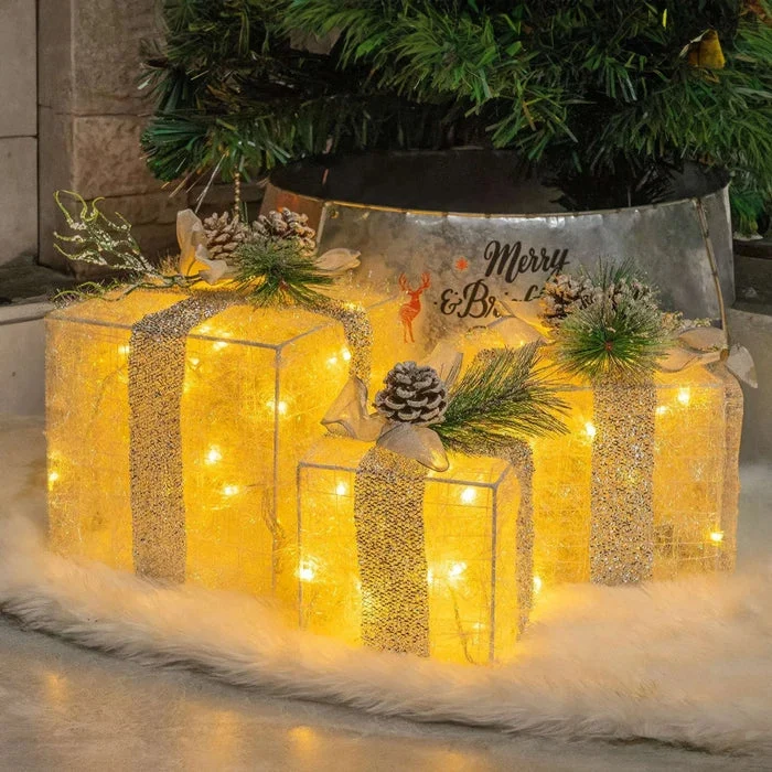 Kerstdecoratie – verlichte cadeaudozen met dennenappels en berijpt groen