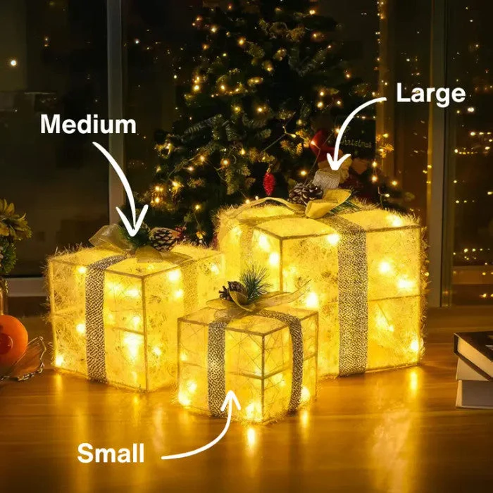 Kerstdecoratie – verlichte cadeaudozen met dennenappels en berijpt groen