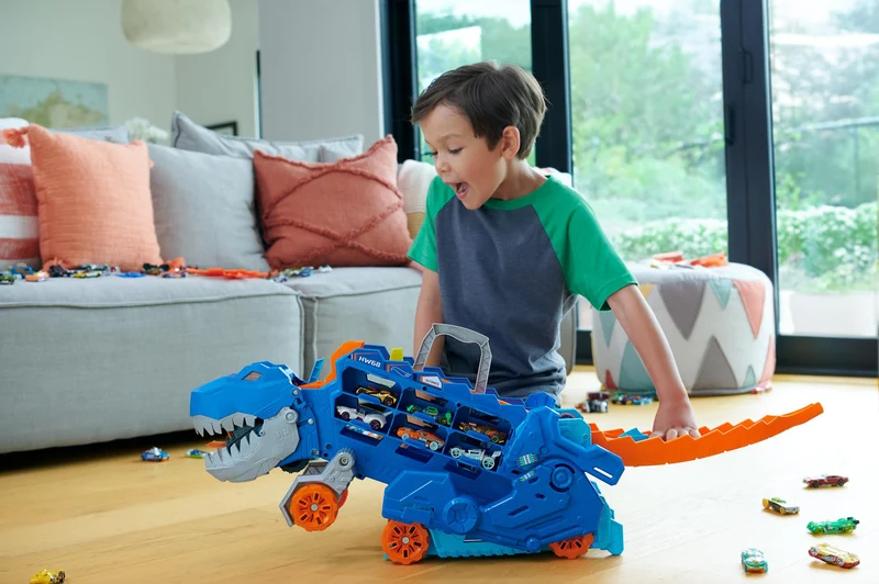 Hot Wheels City 'Let's Race' Netflix - Mega Dino Trasportatore, pista da corsa che si trasforma in un T-Rex, playset con luci e suoni, box per riporre 20 macchinine in scala 1:64, 4+ anni, HNG50
